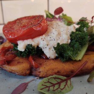 Chickpea Omelette – with roasted plum tomato, kale, harissa-spiced peppers & onions topped with hummus.